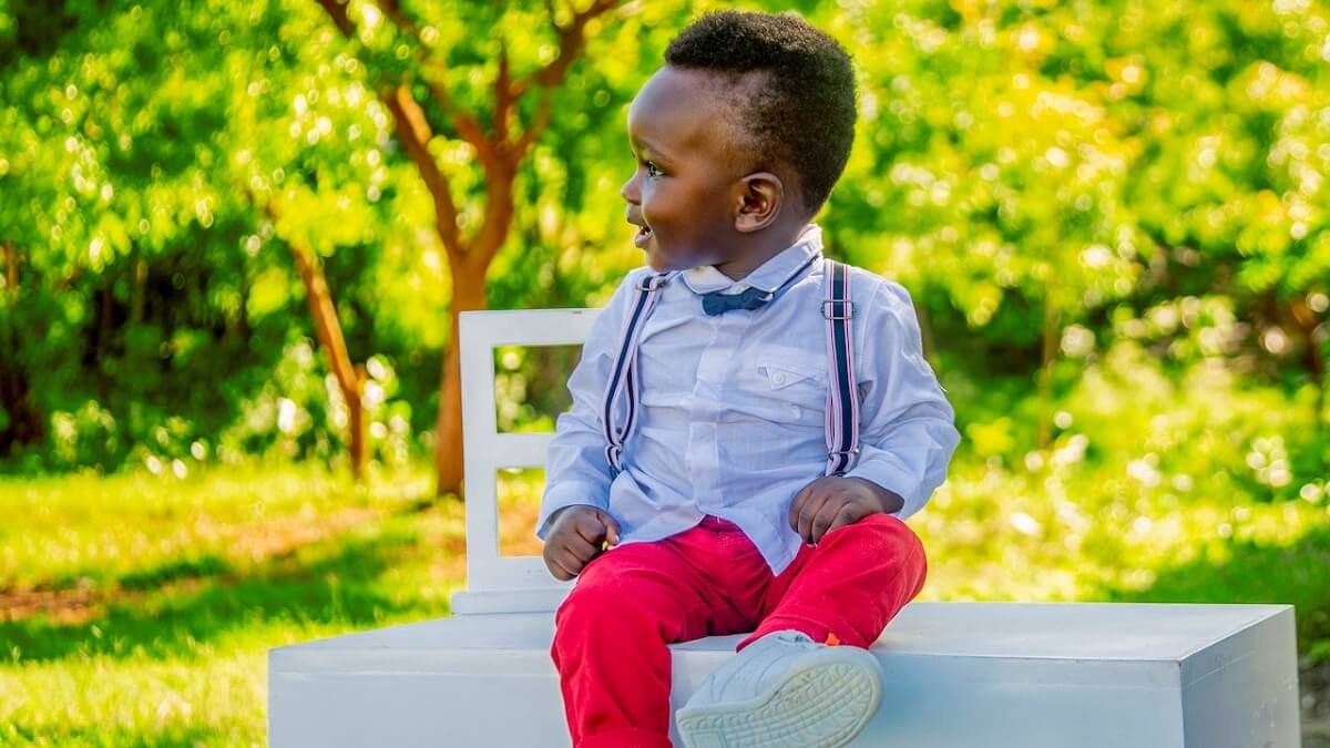 Menino com calça vermelha e camisa social, com suspensório