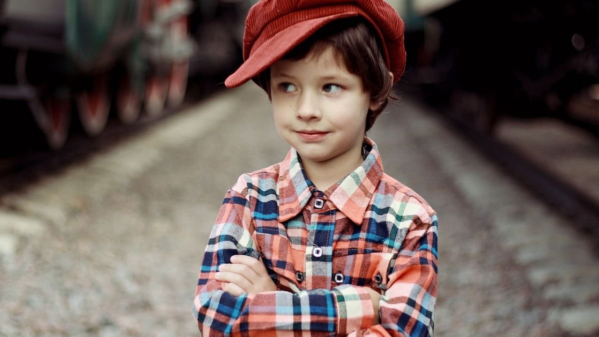 crian&ccedil;a com bone vermelho e camisa xadrez