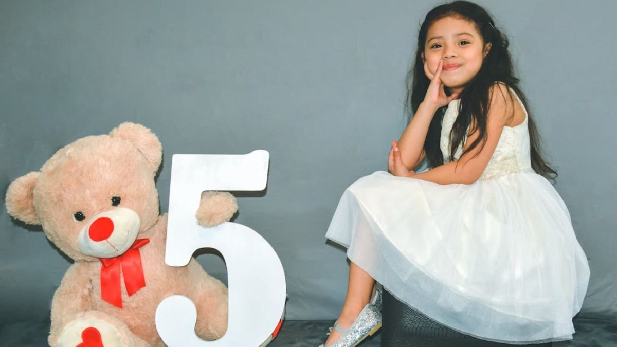 menina com vestido branco com ursinho do lado